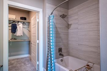 A bathroom with a white tub and a shower curtain.